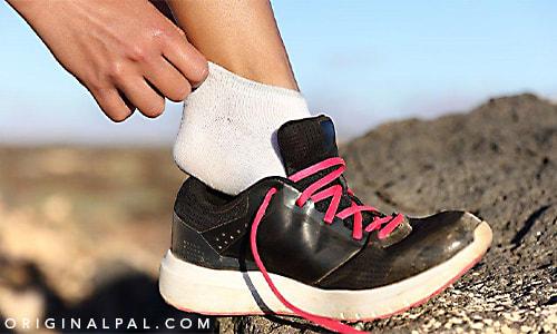 پوشیدن کفش ورزشی مشکی در کوه بر روی سنگ